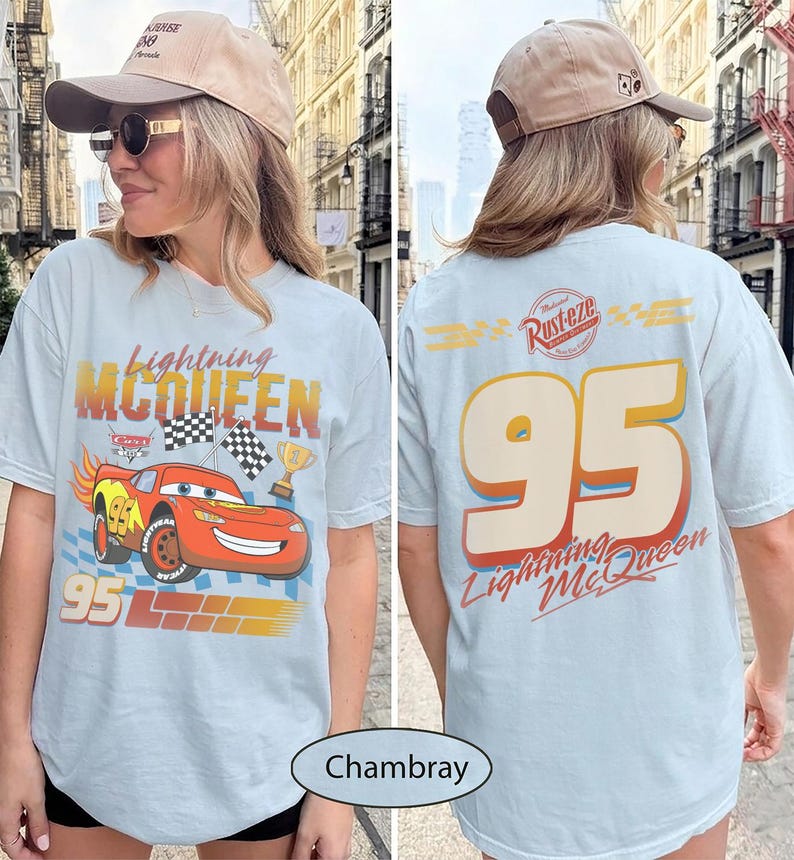 May include: Light blue t-shirt featuring Lightning McQueen from the Cars movie. The front graphic shows the character, checkered flags, and the number 95. The back displays the number 95, the text "Lightning McQueen", and the Rust-eze logo.