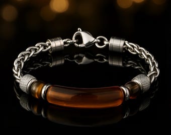 May include: A stainless steel bracelet with a chain link design. The bracelet features a central amber-colored, curved bar and is secured with a clasp. The bracelet has a polished finish and is displayed on a reflective black surface.