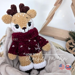 May include: A handmade crochet deer plushie with a tan body, white spots, and brown antlers. It wears a burgundy sweater with white snowflake details and white-trimmed boots. The text "LOW SEW crochet pattern" is visible.