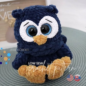 May include: A handmade navy blue crochet owl with large, glittery blue eyes and a tan beak and feet. The owl has a white outline around the eyes and the text "LOW SEW crochet pattern". The owl is a soft, plush toy.