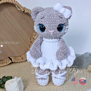 May include: A handmade grey and white crochet cat doll wearing a white tutu and bow. The cat has large blue eyes and a pink nose. The doll is displayed on a woven mat with the text "LOW SEW crochet pattern".