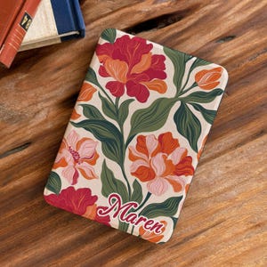 May include: A rectangular e-reader case featuring a cream background with a floral pattern of large red, orange, and pink flowers with dark green leaves. The name Maren is printed in a red cursive script font at the bottom of the case.