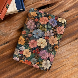 May include: A rectangular e-reader cover featuring a dense, colorful floral pattern on a dark background. The design includes various flowers in shades of pink, orange, yellow, blue, and white, arranged in a repeating botanical print across the surface.