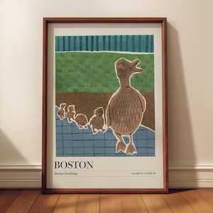 Könnte beinhalten: Gerahmter Kunstdruck mit einer braunen Illustration einer Ente und Entenküken. Das Kunstwerk ist vor einem grünen und blauen Hintergrund platziert, mit dem Wort "BOSTON" und "Garden Ducklings" am unteren Rand. Der Druck ist in einem Holzrahmen.