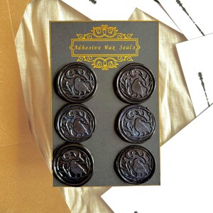 May include: Six black adhesive wax seals with a bird and foliage design. The seals are displayed on a grey card, with the words "Adhesive Wax Seals" in gold. The seals are circular and have a detailed, embossed appearance.