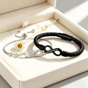 Puede incluir: Una pulsera de cadena plateada con un dije de infinito con cristales grabado con Smith y David, junto a una pulsera de cuero trenzado negro con un dije de infinito negro grabado con Mireyal y Ericayl.