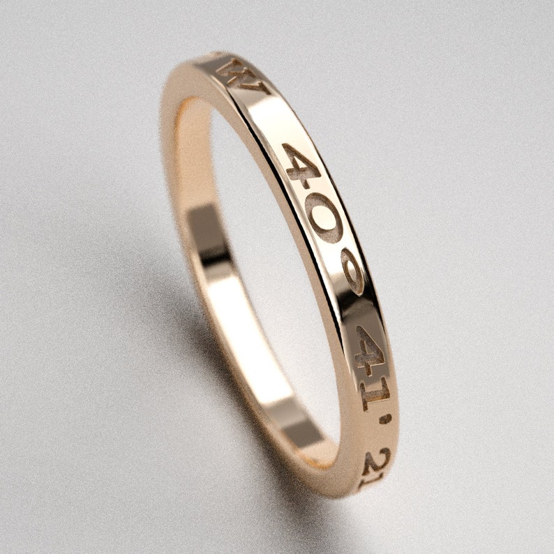 May include: A gold band ring with the numbers 4:00, 4:11, and 2:1 engraved on the outside.