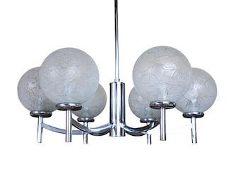 May include: A chrome chandelier featuring five frosted glass globe shades. The light fitting has a central stem and curved arms supporting the globes. The shades have a cracked ice appearance.