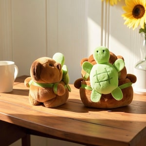 May include: Two plush toys, one brown bear-like figure and one brown bear-like figure carrying a small light green turtle plush on its back. The turtle has a dark green stitched grid pattern on its shell. Both figures are made of soft fabric.