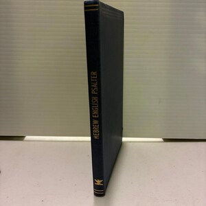 Pode incluir: Um livro azul marinho com letras douradas que dizem "HEBREW ENGLISH PSALTER". O livro tem um emblema dourado na parte inferior e detalhes dourados na lombada. O livro está em pé.