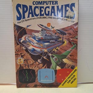 May include: Vintage "Computer Spacegames" box featuring a retro sci-fi illustration of spaceships and planets. The box includes the text "For ZX Spectrum, ZX81, BBC, TRS-80, APPLE, VIC ET" and "Games Programs for your Micro".