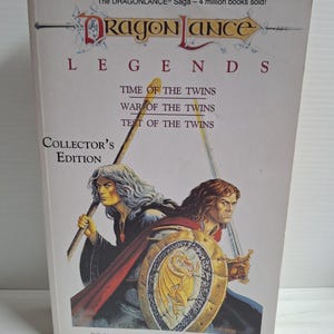 以下が含まれることがあります： 「Time of the Twins」「War of the Twins」「Test of the Twins」というタイトルのDragonlance Legends Collector's Editionの本。表紙には、長い灰色の髪で杖を持った人物と、茶色の髪で盾を持った人物の2人が描かれています。