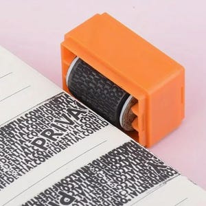 Op de afbeelding: Een oranje privacy roller stempel met een zwarte inktroller wordt getoond die gedeeltelijk een document bedekt. Het document heeft het woord "PRIVÉ" en het woord "VERTROUWELIJK" herhaald.