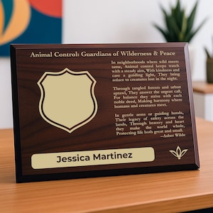 May include: A wooden plaque with the text "Animal Control: Guardians of Wilderness & Peace" and a shield emblem. The plaque has a dark brown finish with gold lettering and a gold nameplate that reads "Jessica Martinez".