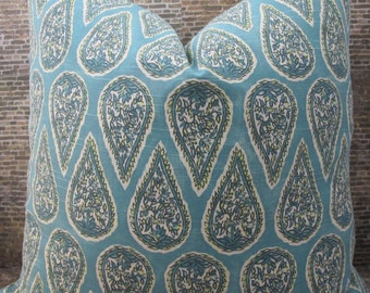 May include: A square decorative pillow with a teal background and a repeating paisley pattern. The paisley design features a white interior with blue and green leaf-like details, outlined with a teal border and a yellow-green trim.