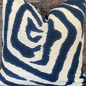 May include: A white and navy blue throw pillow with a swirling, abstract pattern.