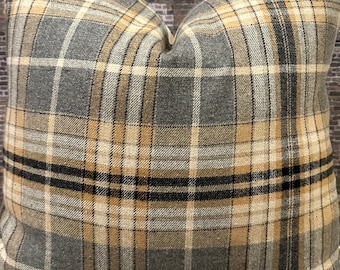 May include: A gray, beige, and black plaid throw pillow with a square shape.