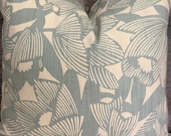 Könnte beinhalten: Quadratisches Zierkissen mit floralem Muster. Das Kissen hat ein hellblaues und cremefarbenes botanisches Design. Das Muster besteht aus stilisierten Blumen und Blättern. Das Kissen ist aus einem strukturierten Stoff gefertigt.