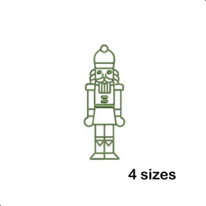 May include: A green outline of a nutcracker soldier on a white background. The nutcracker has a hat, mustache, and a skirt. The text "4 sizes" is below the nutcracker.