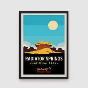 May include: Framed art print depicting a stylized landscape of Radiator Springs National Park. The artwork shows a yellow rock formation under a blue sky with a sun. Text reads "Radiator Springs National Park" and "Gateway To Monument Valley."