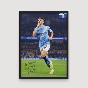 Peut inclure: Tirage encadré d'un joueur de football en maillot bleu clair et short blanc, courant sur un terrain vert. Le maillot affiche "ETIHAD AIRWAYS". L'impression comprend le texte manuscrit "To Name Best Wishes Phallen".