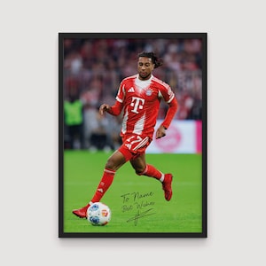 Peut inclure: Impression encadrée d'un joueur de football en uniforme rouge et blanc, frappant un ballon de football sur un terrain vert. L'impression comprend le texte "To Name Best Wishes" et une signature.