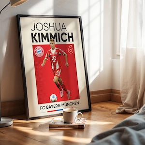 Pode incluir: Um cartaz emoldurado com um gr&aacute;fico do jogador de futebol Joshua Kimmich no uniforme vermelho e branco do FC Bayern M&uuml;nchen. O design inclui o texto JOSHUA KIMMICH, o n&uacute;mero 6, o log&oacute;tipo da equipa e o texto FC BAYERN M&Uuml;NCHEN em fundo creme.