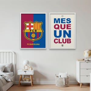 May include: Two framed posters featuring FC Barcelona imagery. One displays the team's crest with a red and blue background, the other reads "MES QUE UN CLUB" in blue and burgundy. Both are in white frames.