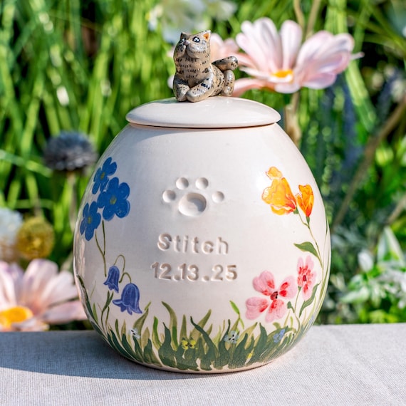 A fully custom handmade ceramic cat urn with a sculpted pet figurine on top — heartbreakingly personal, technically impressive, and something you truly cannot find anywhere else.