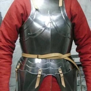 May include: A polished metal breastplate and waist armour with leather straps. The armour is worn over a red long-sleeved shirt and orange trousers. The text "MEDIVAL KNIGHT" is visible in the upper left corner.