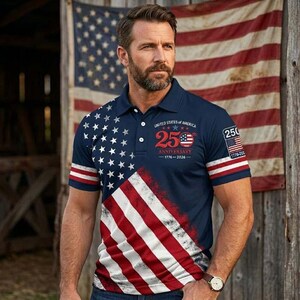 May include: A navy blue polo shirt featuring a diagonal American flag pattern with white stars on the upper left and red and white stripes on the lower right. The chest displays text reading United States of America 250 Anniversary 1776-2026.
