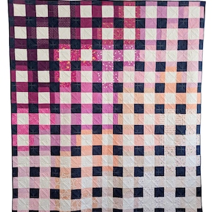 Może przedstawiać: Kołdra w kratkę w kolorze czarnym, białym, różowym i czerwonym. Kołdra wykonana jest z kwadratów w różnych kolorach i wzorach, a kwadraty są ułożone w kratkę. Kołdra jest pikowana prostym ściegiem.
