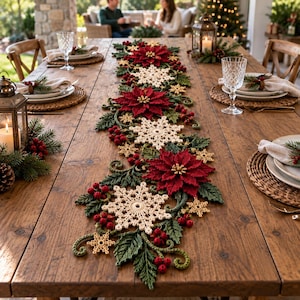 May include: A long, decorative table runner featuring a crochet design of deep red poinsettia flowers, cream-colored snowflakes, dark green leaves, and small red berries arranged in a continuous pattern along the center of a wooden table.