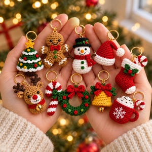 May include: A collection of ten small, crocheted Christmas-themed keychains featuring a gingerbread person, snowman, reindeer, Christmas tree, Santa hat, stocking, candy cane, wreath, bell, and a mug of hot cocoa, all attached to gold-tone rings.