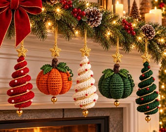 Pode incluir: Cinco ornamentos de crochê pendurados em fila, incluindo três árvores em espiral nas cores vermelho, branco e verde escuro, e duas abóboras redondas nas cores laranja e verde escuro. Cada ornamento tem uma estrela dourada no topo e uma pequena conta dourada na base.