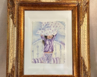 May include: A framed watercolor painting depicting a child in purple pajamas holding a patterned blanket over their head. The artwork is encased in an ornate, distressed gold and cream-colored frame with intricate carved details and a white mat.