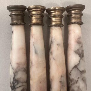 K&ouml;nnte beinhalten: Vier antike Stifthalter aus Marmor und Messing. Die Stifthalter haben einen wei&szlig;en und grauen Marmork&ouml;rper mit einem Messingoberteil und -sockel. Das Messing hat eine warme Goldfarbe. Der Marmor hat ein nat&uuml;rliches Aderungsmuster.