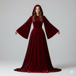 May include: A long, flowing burgundy velvet gown with a hooded neckline and dramatic bell sleeves. The dress features a fitted bodice and a full, floor-length skirt. The gown is designed for a formal occasion.