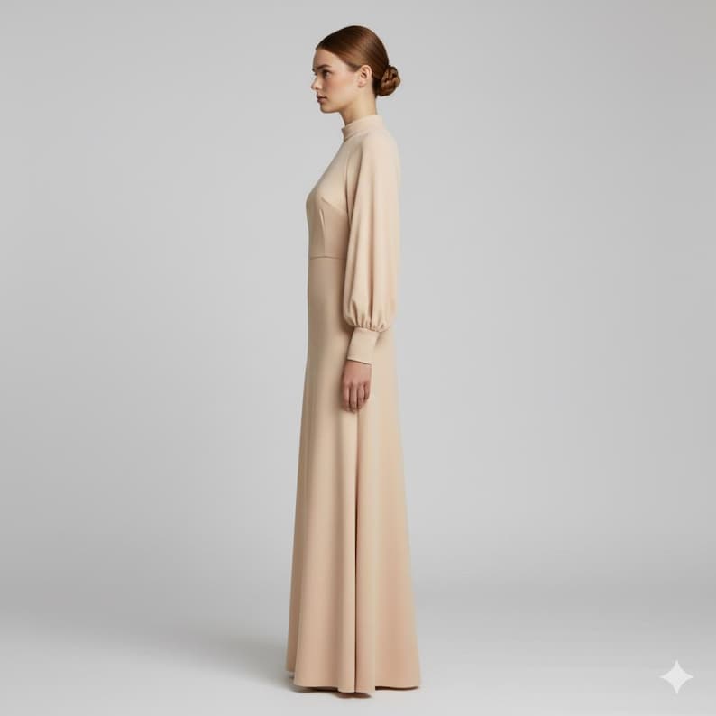 May include: A long, beige dress with a high neckline and long sleeves. The dress has a fitted bodice and a flowing skirt. The sleeves are gathered at the wrist. The dress is made of a smooth, solid fabric and is suitable for formal occasions.