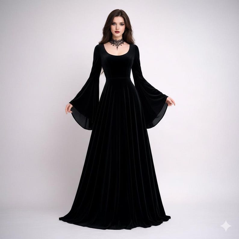 Pode incluir: Um vestido longo de veludo preto com decote redondo e mangas largas. O vestido tem um corpete justo e uma saia fluida. Um colar gargantilha preto &eacute; usado. Ideal para eventos formais ou tem&aacute;ticos, o vestido &eacute; elegante.