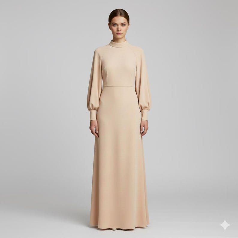 May include: A long, beige dress with a high neckline and long sleeves. The dress features a fitted bodice and a flowing skirt. The sleeves are gathered at the wrist, creating a slight puff. The dress is made of a smooth, solid fabric.