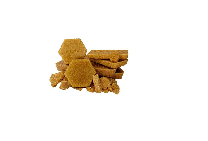May include: A collection of golden-yellow beeswax blocks and fragments. The blocks are in various shapes, including hexagonal and rectangular forms. The word "BEESWAX" is imprinted on some of the blocks. The image is set against a white background.
