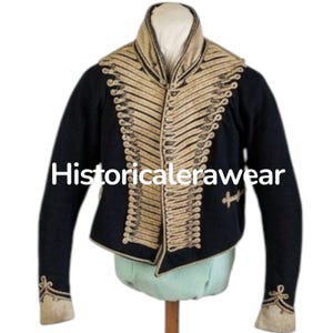 May include: A navy blue jacket with gold-coloured trim and decorative buttons. The jacket features a high collar and ornate detailing along the front and sleeves. The text "Historicalerawear" is visible on the front of the jacket.