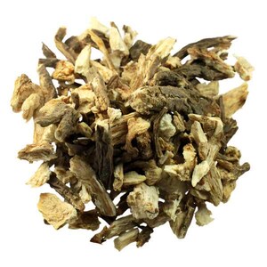 May include: A close-up of a pile of dried burdock root pieces. The pieces are a mix of light tan and dark brown, with a rough, textured surface. The image highlights the fibrous structure of the root. The background is plain white.
