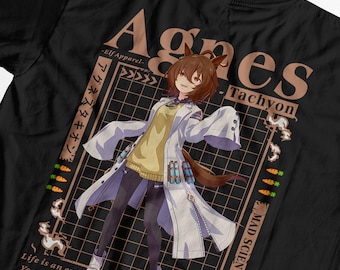 Puede incluir: Camiseta negra con una ilustración de estilo anime de Agnes Tachyon, una científica loca. El diseño incluye texto en inglés y japonés, una cuadrícula e ilustraciones de zanahorias. El personaje lleva una bata de laboratorio.