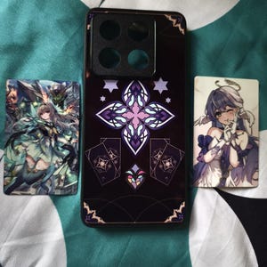 Pode incluir: Uma capa de smartphone preta com um design central de cruz em estilo vitral roxo e branco, ladeada por dois cart&otilde;es retangulares de personagens de anime. A capa possui um grande recorte quadrado para a c&acirc;mera no topo e padr&otilde;es geom&eacute;tricos.