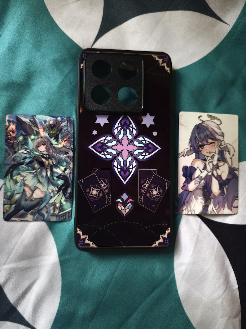 Pode incluir: Uma capa de smartphone preta com um design central de cruz em estilo vitral roxo e branco, ladeada por dois cart&otilde;es retangulares de personagens de anime. A capa possui um grande recorte quadrado para a c&acirc;mera no topo e padr&otilde;es geom&eacute;tricos.