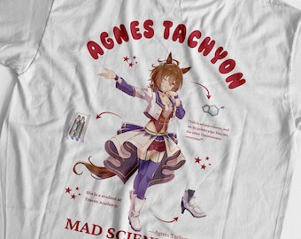 Puede incluir: Camiseta blanca con una ilustración de estilo anime de un personaje con cabello castaño y un atuendo morado y blanco. El texto "AGNES TACHYON" está arqueado en la parte superior, con "MAD SCIENTIST" debajo.