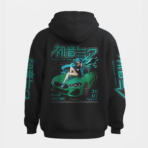 May include: A black hooded sweatshirt featuring a graphic on the back of an anime character with teal hair sitting on a green sports car. The design includes the text Hatsune Miku, Vocaloid Street Mode, 20 07, August 31, and Japanese characters.