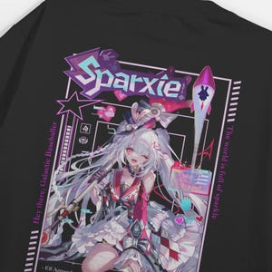 Może przedstawiać: Czarny t-shirt z kolorowym wzorem w stylu anime. Grafika zawiera słowo "Sparxie" w kolorze fioletowym, postać z białymi włosami i rakietę. Tekst brzmi "Hey there, Galactic Baseballer" i "The world is full of sparkle."